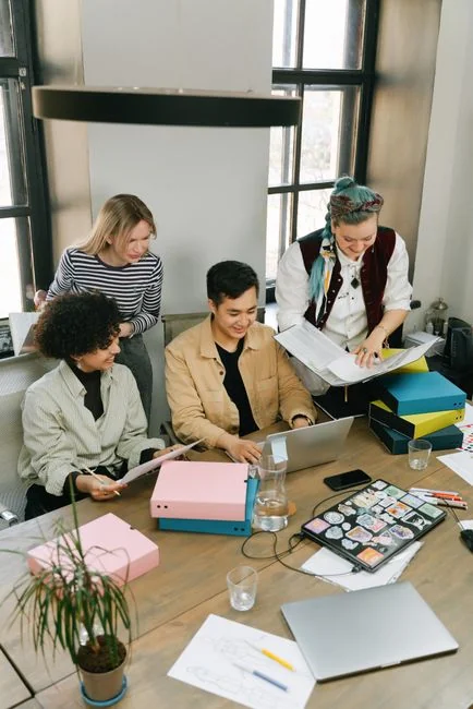 A modern office setup featuring a laptop and a whiteboard schedule for social media platforms.